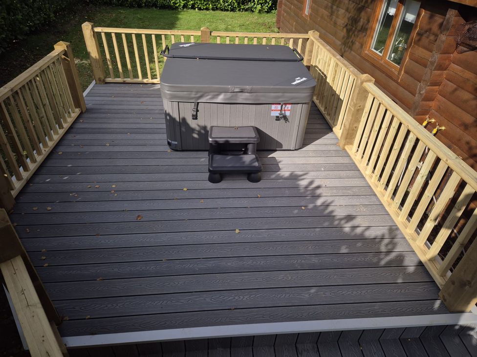A deck with a hot tub and steps at Willow in Dolton