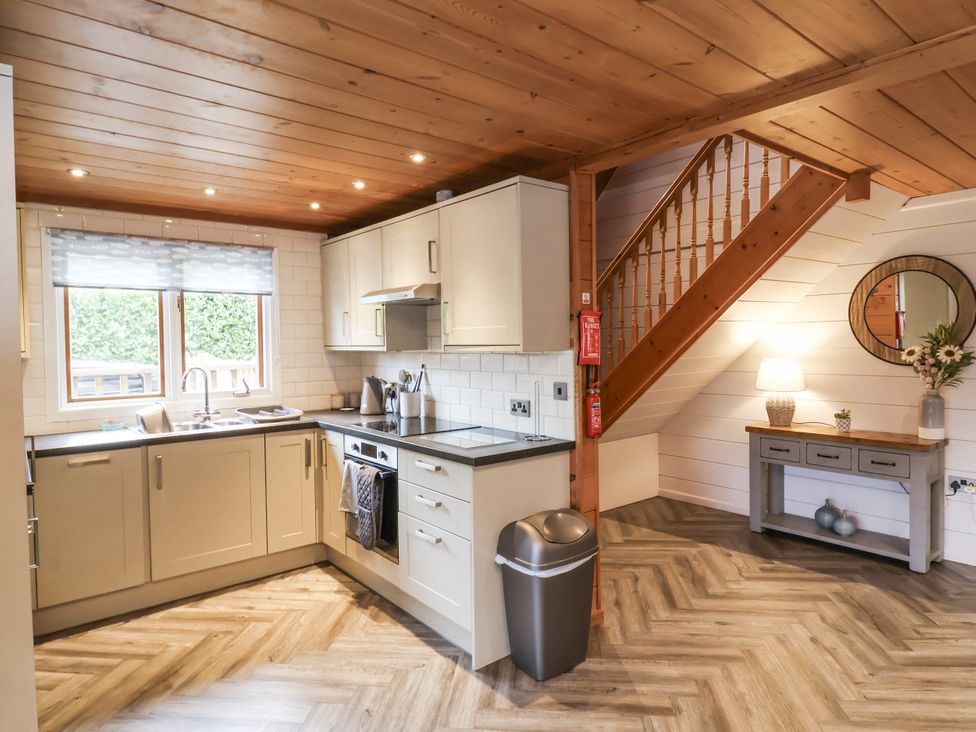 A kitchen with a stove, sink, and window at Willow in Dolton