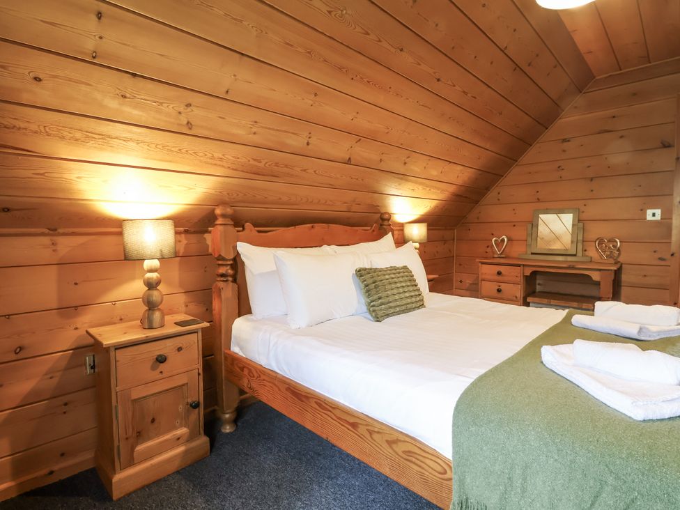 A bedroom with a wooden bed and nightstand at Willow in Dolton