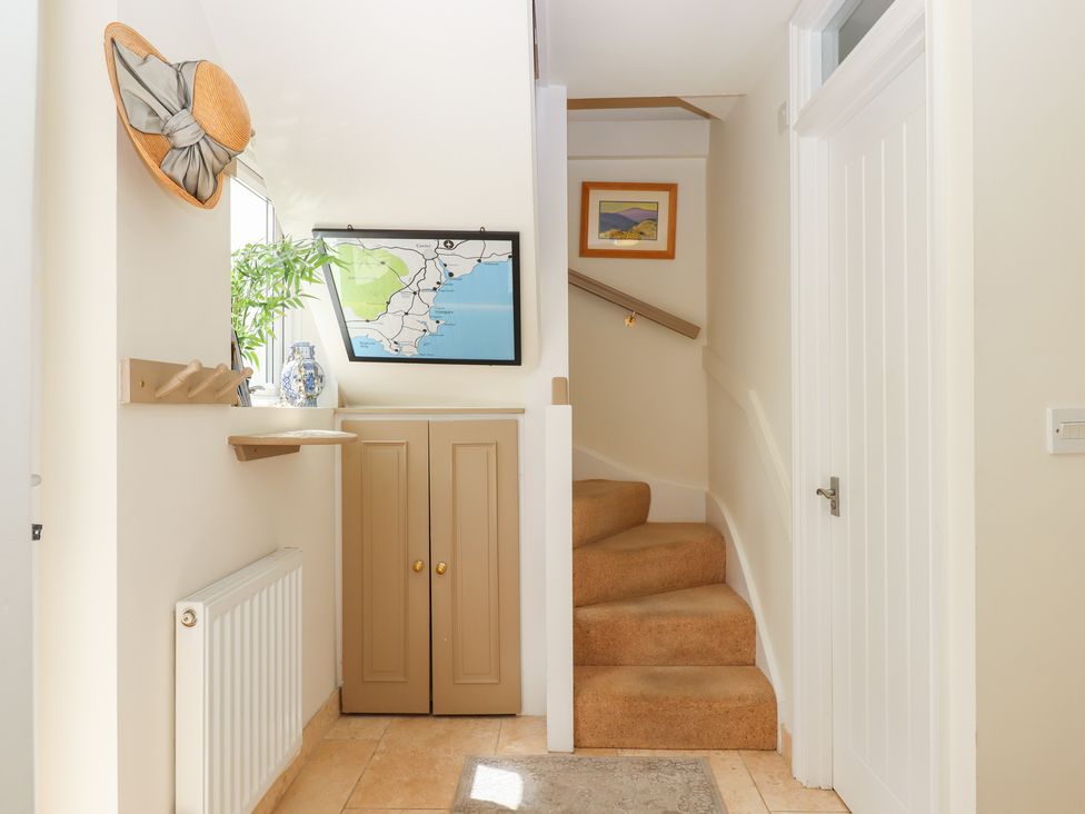 A hallway with stairs and a map at 5 Exe Street Topsham