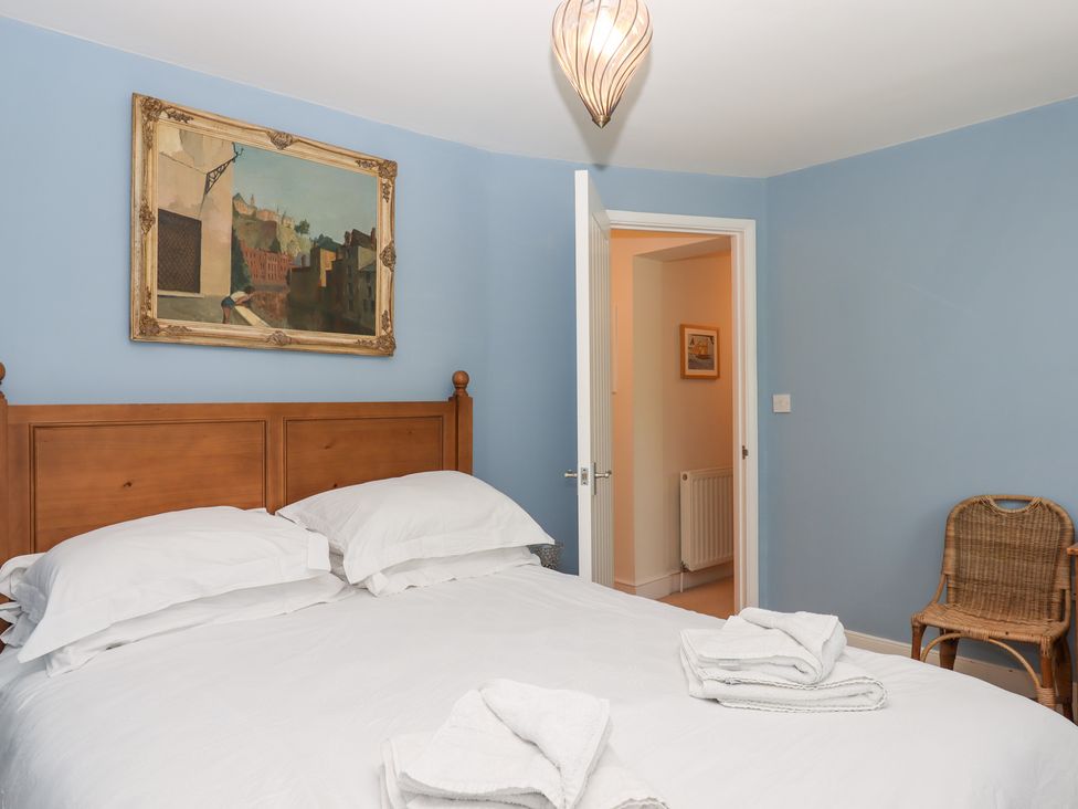 A bedroom with a bed and painting on the wall at 5 Exe Street Topsham