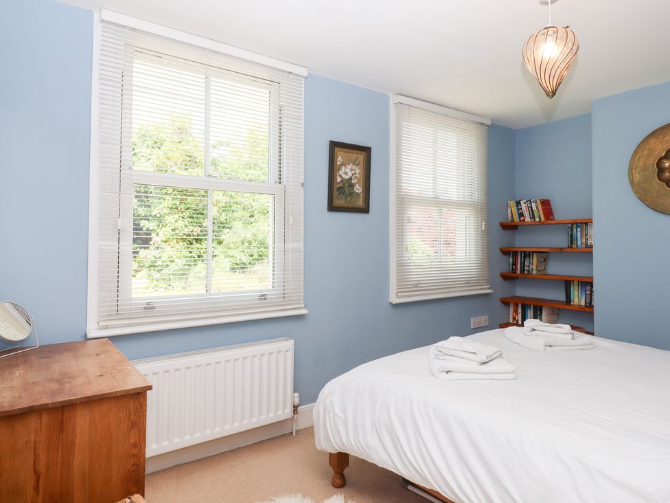 A bedroom with a bed and bookshelf at 5 Exe Street Topsham
