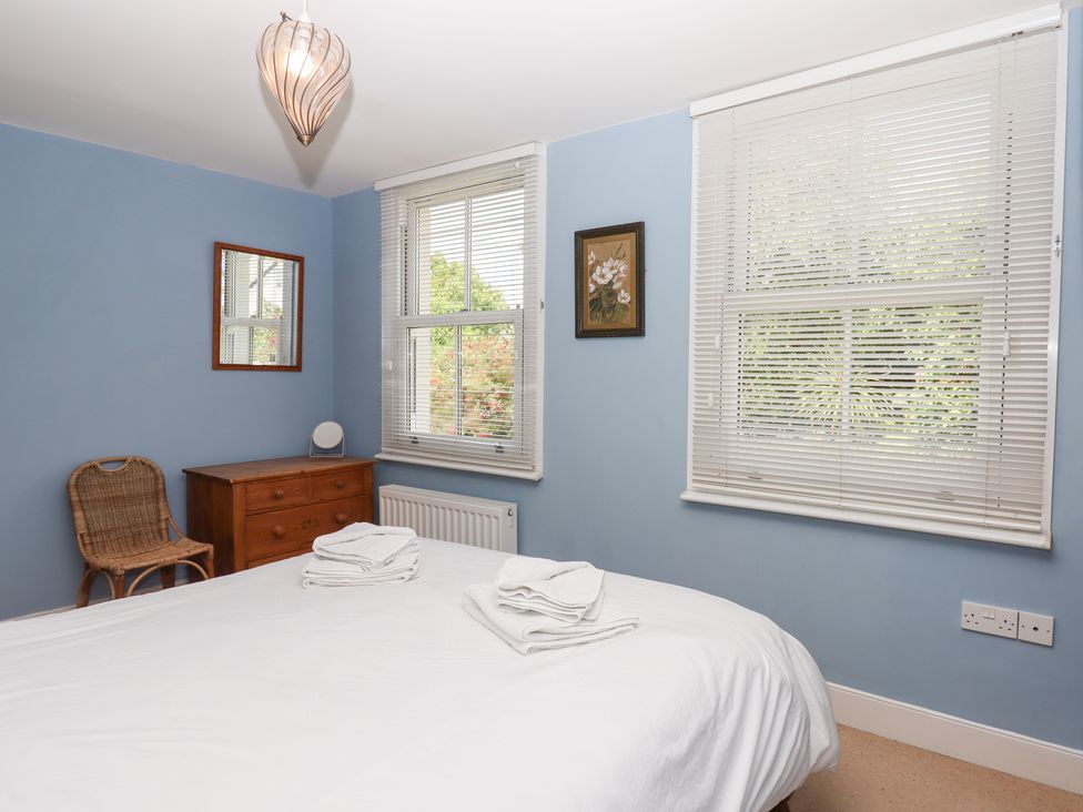 A bedroom with a bed and a chair at 5 Exe Street Topsham