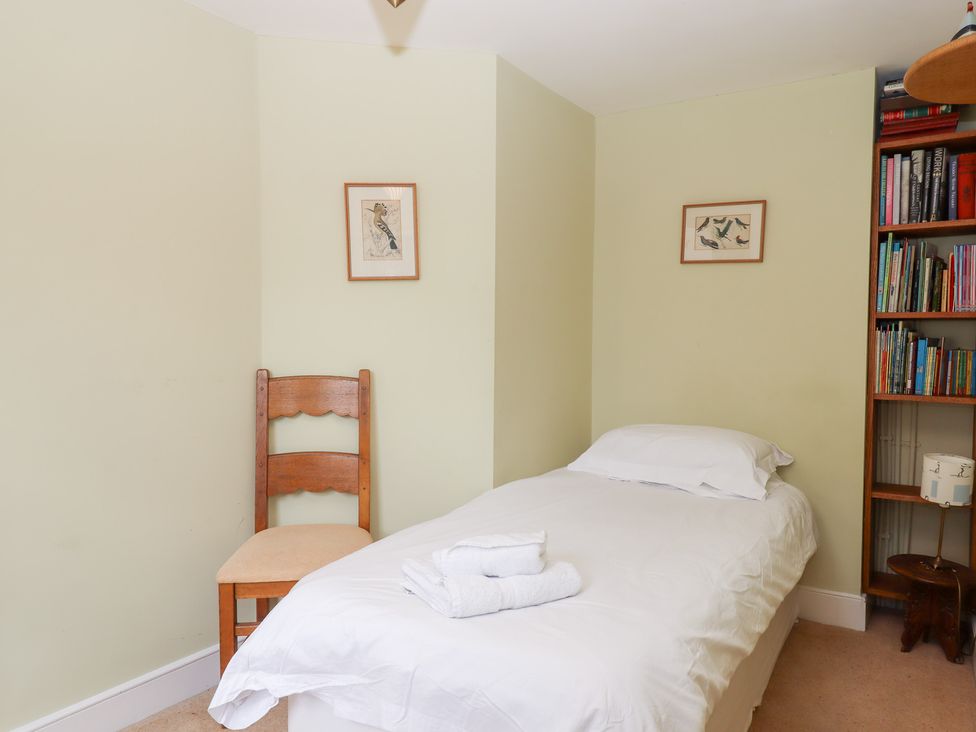 A bedroom with a single bed and a chair at 5 Exe Street Topsham