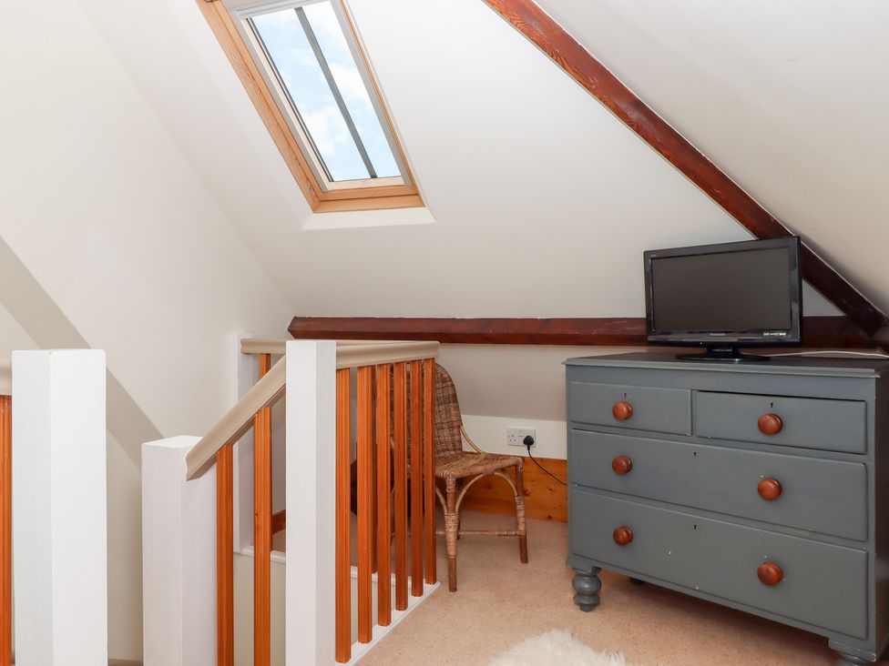 A loft area with a dresser and television at 5 Exe Street Topsham