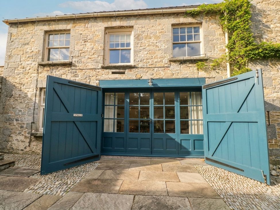 A stone building with double doors and windows at The Stalls at Gileston Manor St Athan