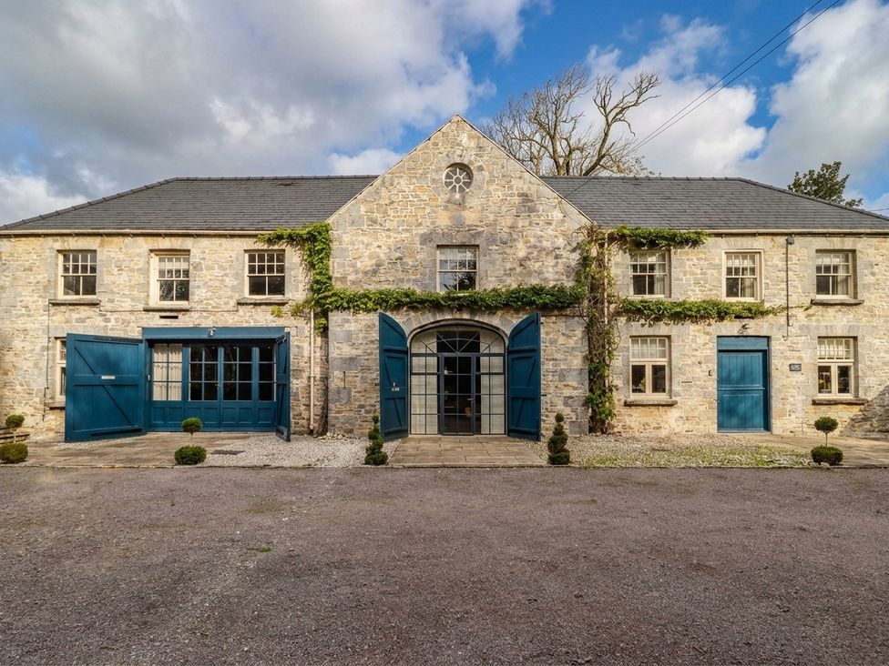 Exterior view of a stone building with double doors at The Stalls at Gileston Manor, St Athan