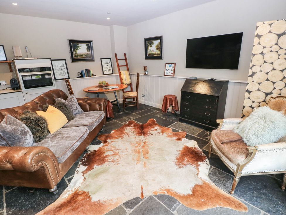 A living room with a sofa and table at The Stalls at Gileston Manor St Athan