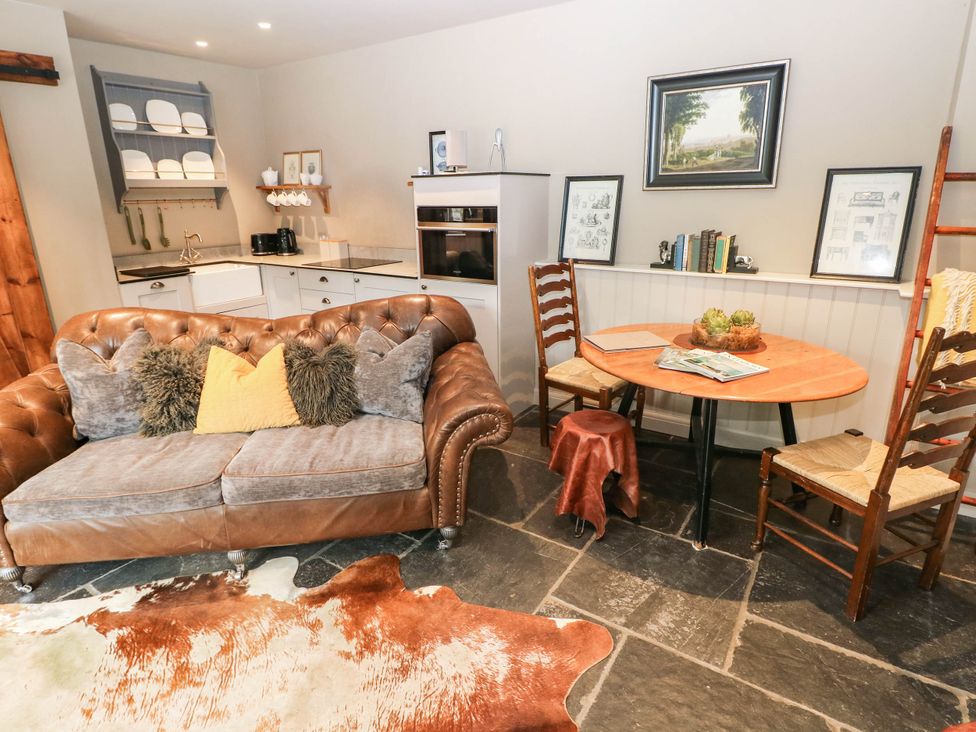 A living room with a sofa and a table at The Stalls at Gileston Manor St Athan