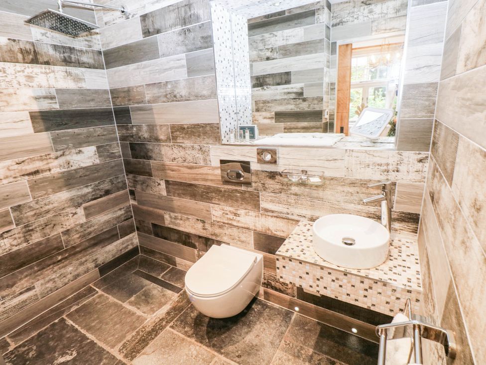 A bathroom with a shower, toilet and wash basin at The Stalls at Gileston Manor St Athan