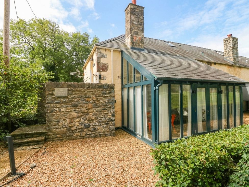 An outdoor view of a conservatory and stone wall at The Coach House at Gileston Manor near St Athan