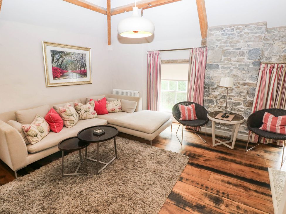 A living room with a sofa and coffee table at The Coach House at Gileston Manor near St Athan