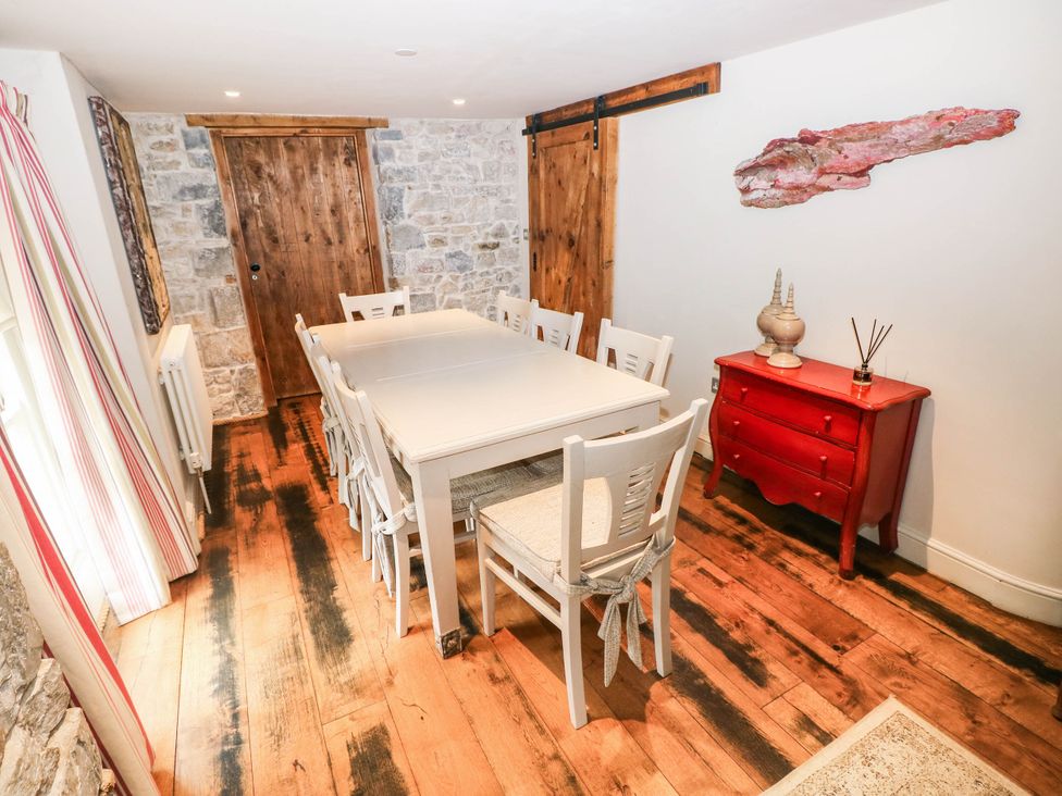 A dining room with a table and chairs at The Coach House at Gileston Manor near St Athan