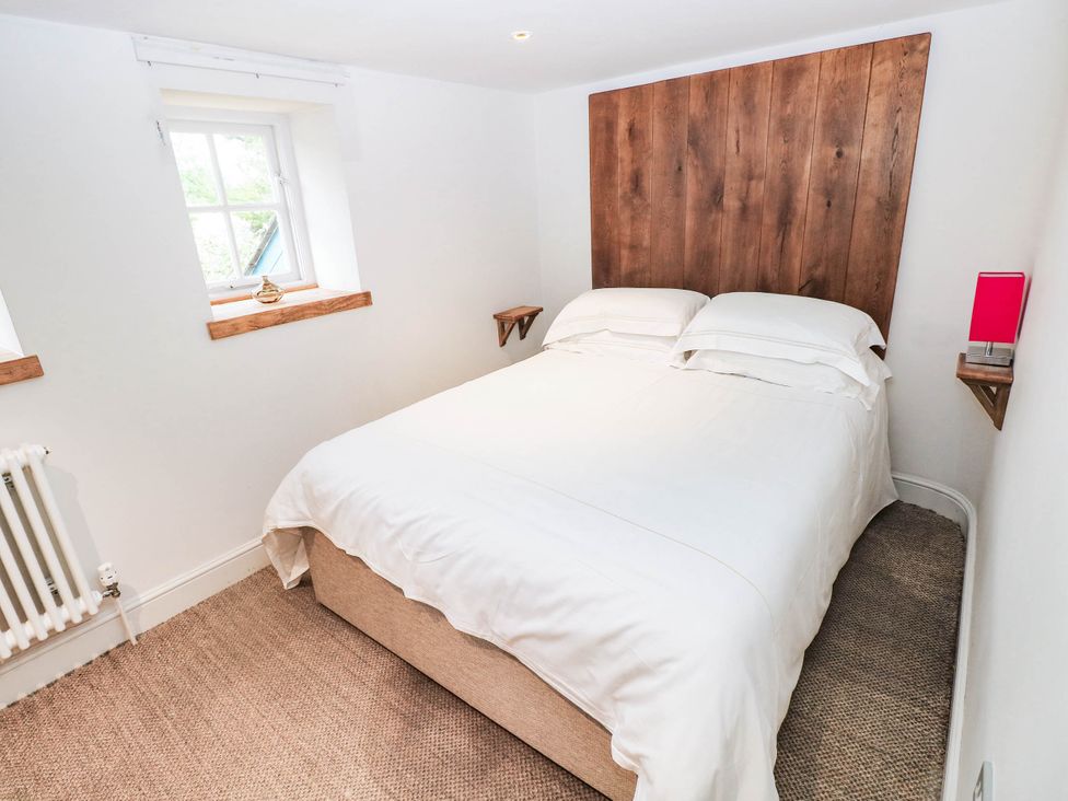 A bedroom with a bed and windows at The Coach House at Gileston Manor near St Athan