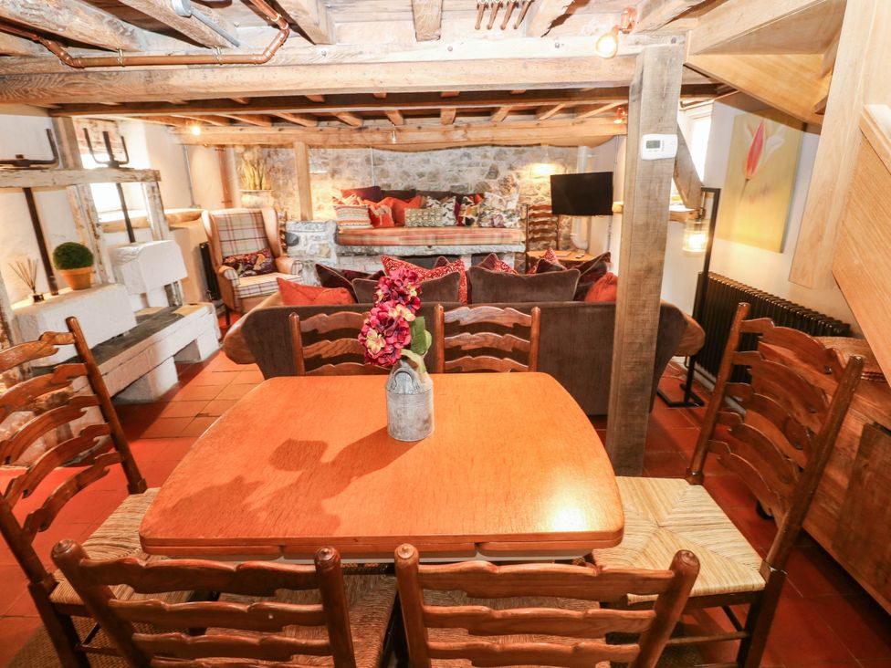 A dining room with a wooden table and chairs at The Cheese House at Gileston Manor near St Athan