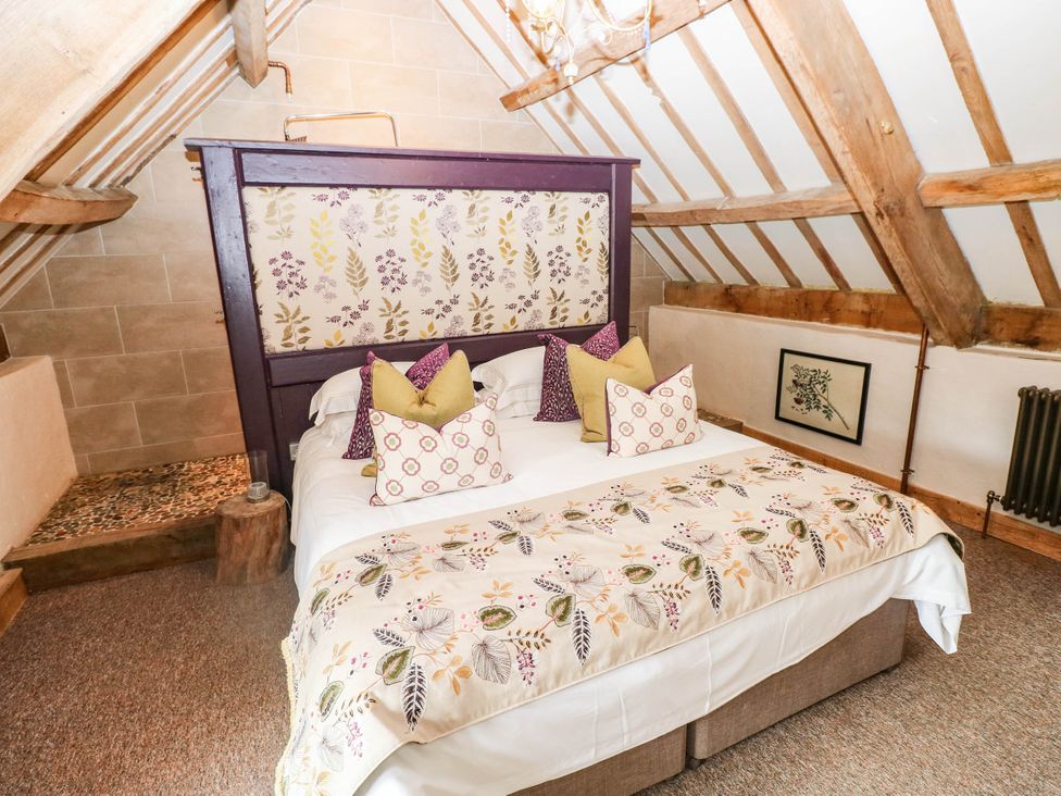 A bedroom with a bed and decorative pillows at The Cheese House at Gileston Manor near St Athan