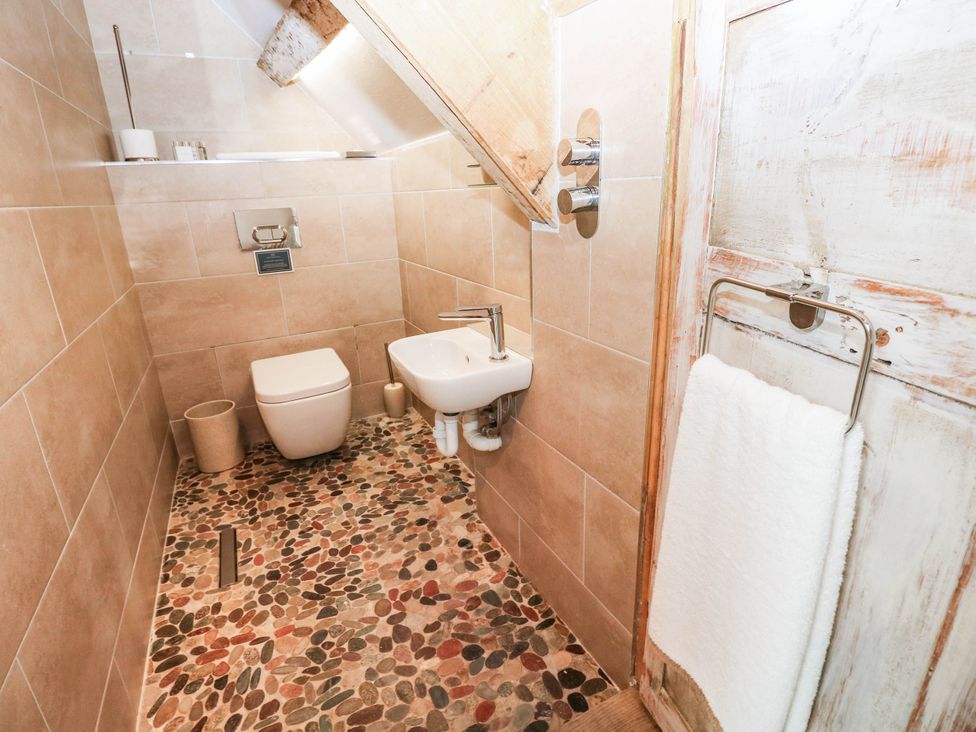 A bathroom with a toilet, bidet, and sink at The Cheese House at Gileston Manor near St Athan