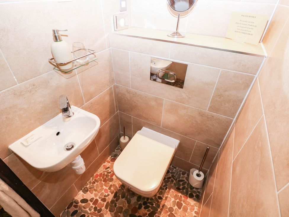 A bathroom with a sink and toilet at The Cheese House at Gileston Manor near St Athan