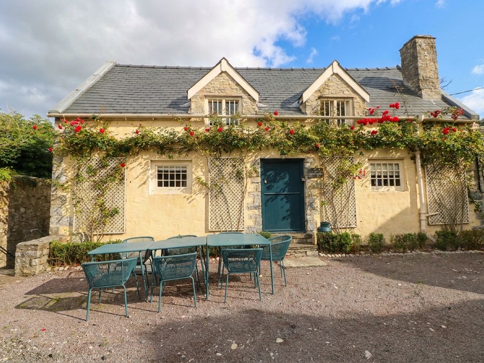 A house with an outdoor table and chairs at The Cheese House at Gileston Manor near St Athan