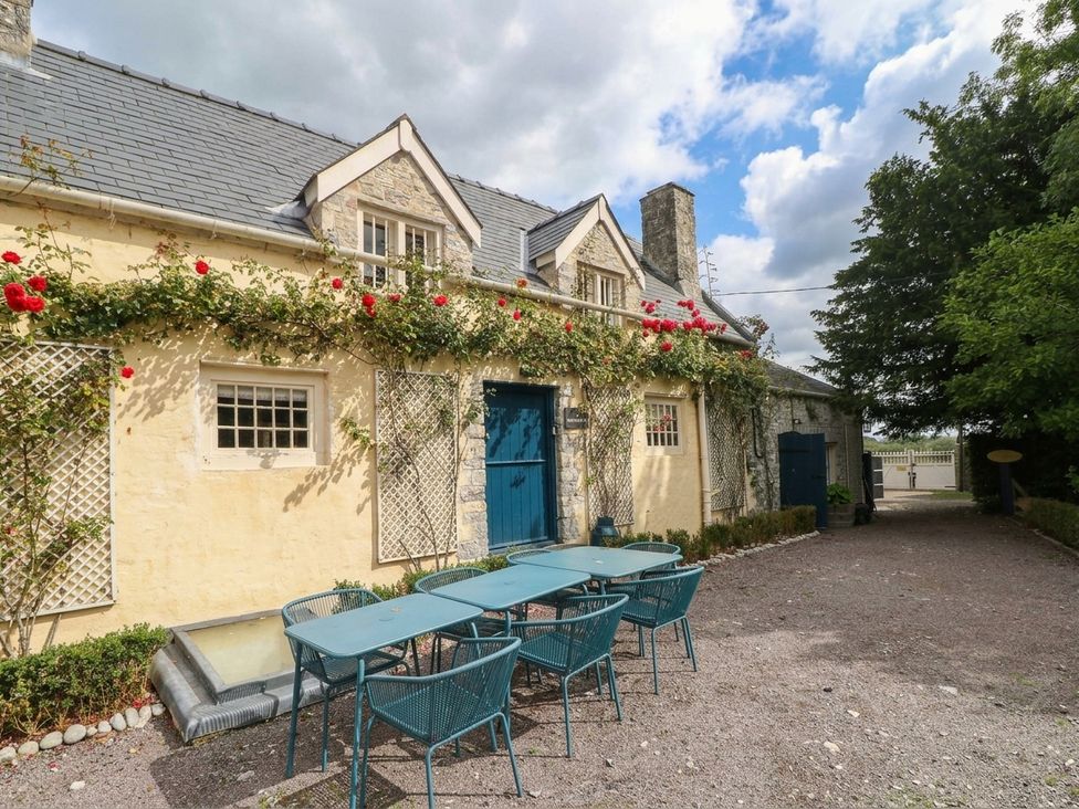 An outdoor area with a table and chairs at The Cheese House at Gileston Manor near St Athan