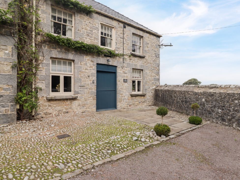 An outdoor area with a stone wall and door at The Stables at Gileston Manor St Athan