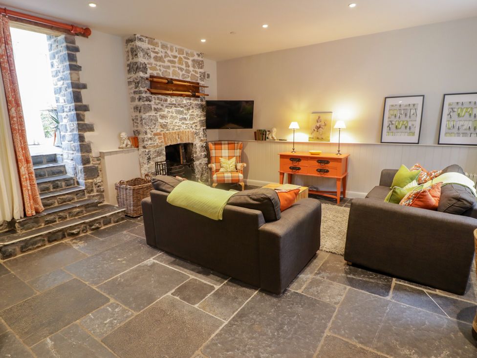 A living room with a fireplace and sofa at The Stables at Gileston Manor St Athan