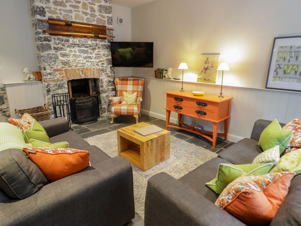 A living room with a fireplace and sofas at The Stables at Gileston Manor St Athan