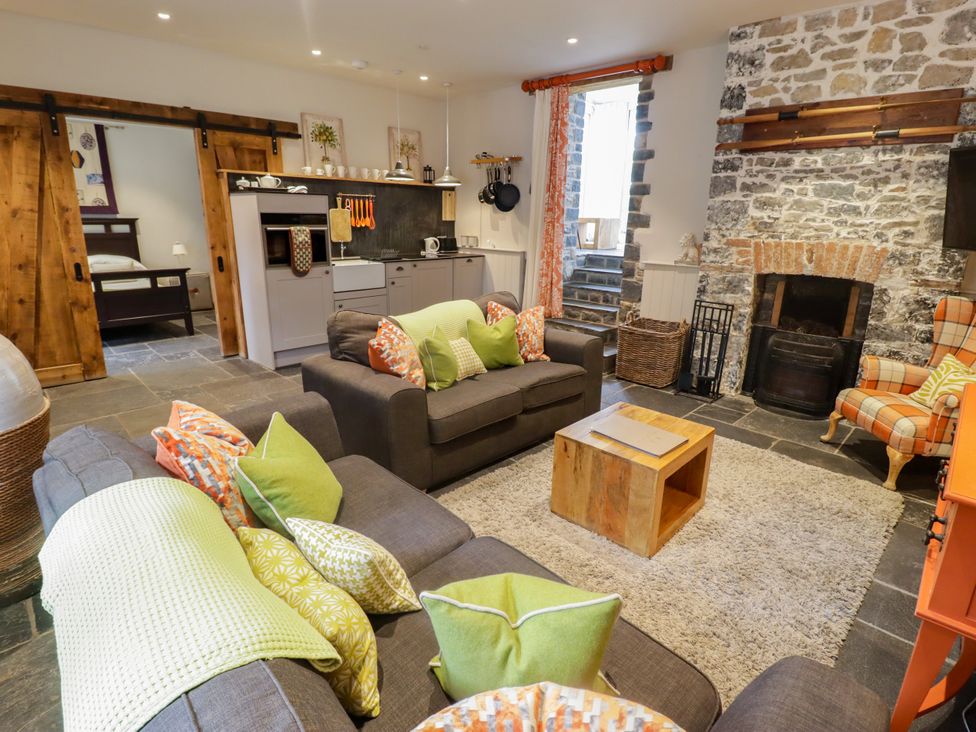 A living room with a sofa and a fireplace at The Stables at Gileston Manor St Athan