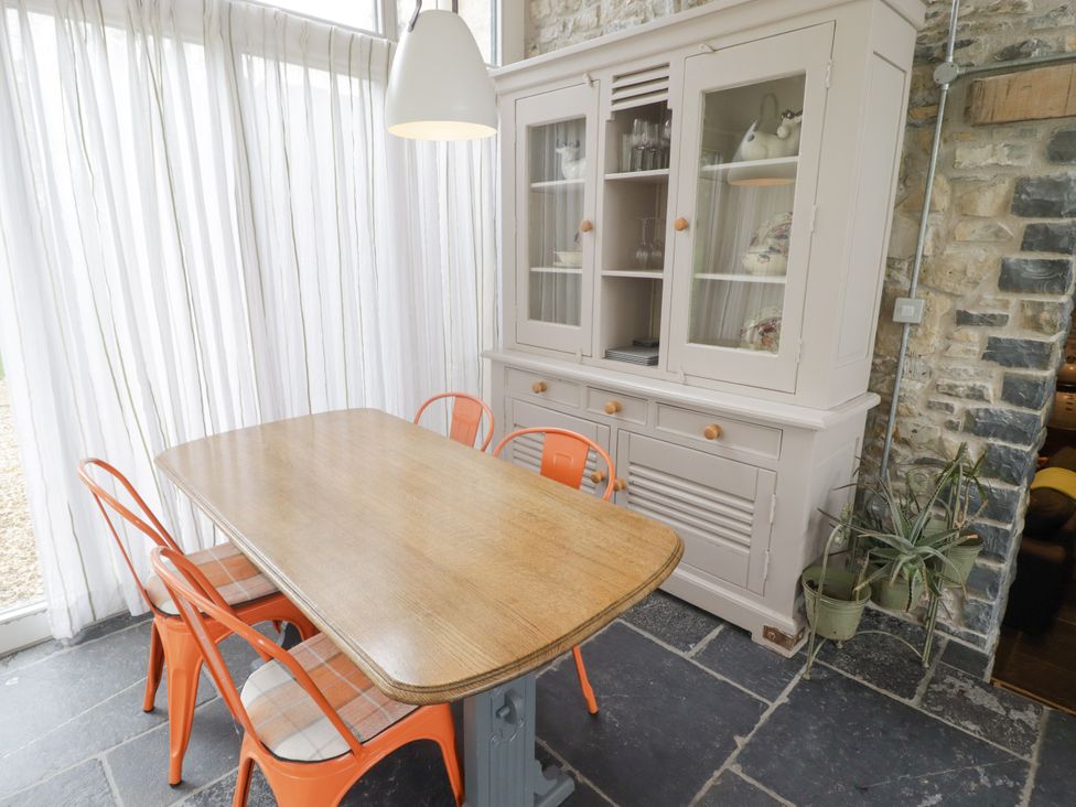 A dining table with chairs and a sideboard at The Stables at Gileston Manor St Athan