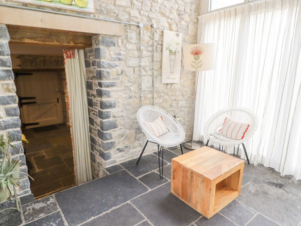 A snug with two chairs and a wooden table at The Stables at Gileston Manor St Athan