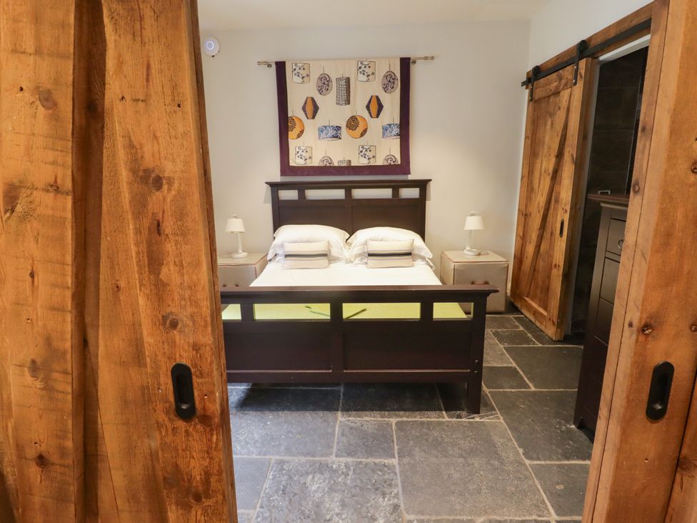 A bedroom with a bed and bedside lamps at The Stables at Gileston Manor St Athan