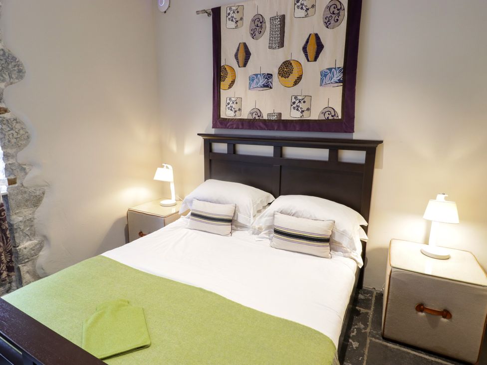A bedroom with a bed and bedside lamps at The Stables at Gileston Manor St Athan
