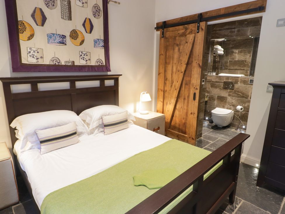 A bedroom with a bed and adjoining bathroom at The Stables at Gileston Manor St Athan