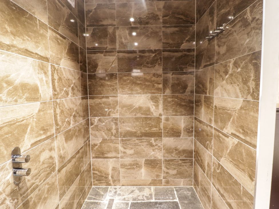 A shower with tiled walls and floor at The Stables at Gileston Manor St Athan