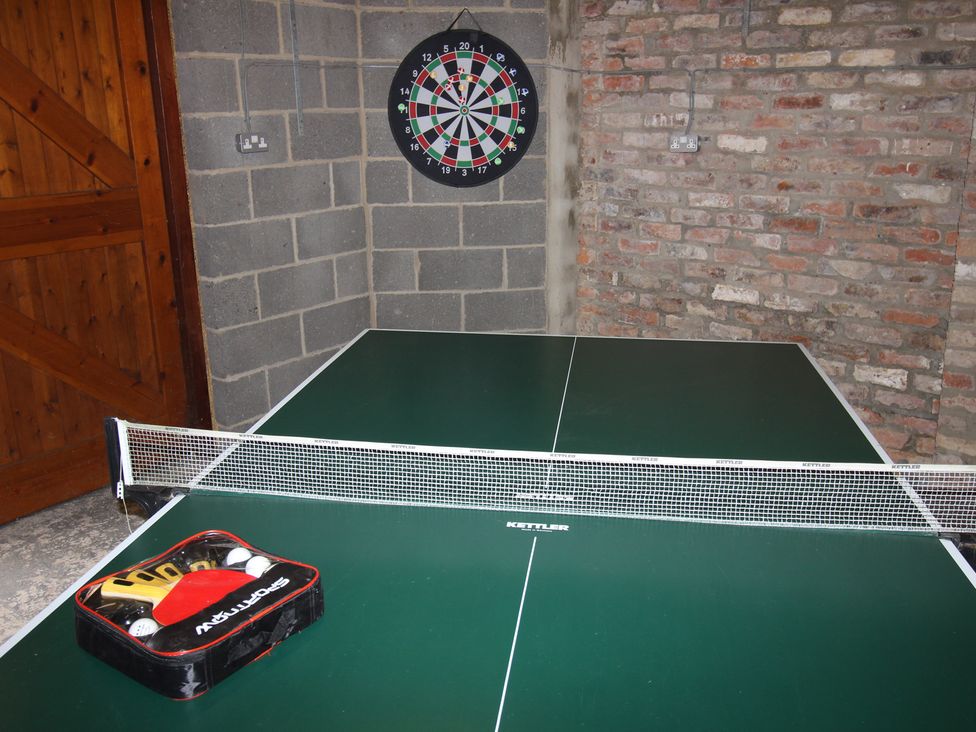 A games room with a table tennis table and a dartboard at The Old Post Office Shipton By Beningbrough near York