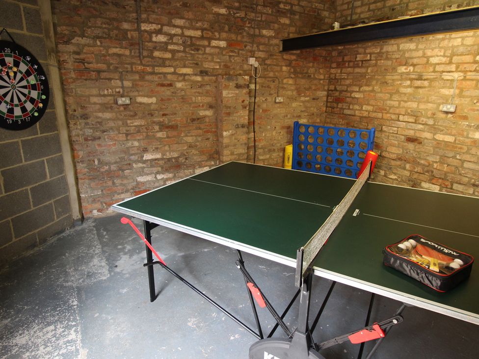 A games room with a table tennis table and dartboard at The Old Post Office Shipton By Beningbrough near York