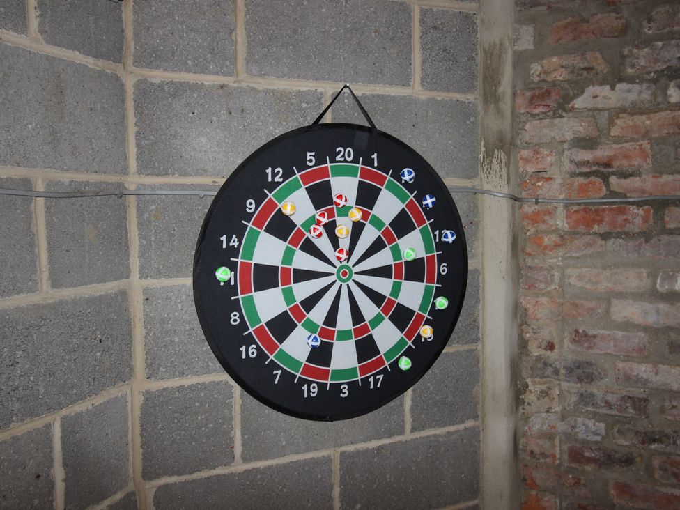 A dartboard mounted on a wall in a game room at The Old Post Office Shipton By Beningbrough near York