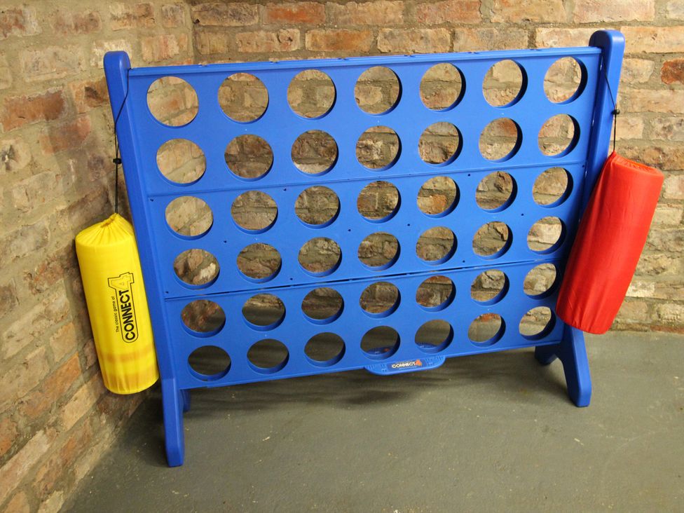 A blue connect four game board with yellow and red bags at The Old Post Office in Shipton By Beningbrough near York