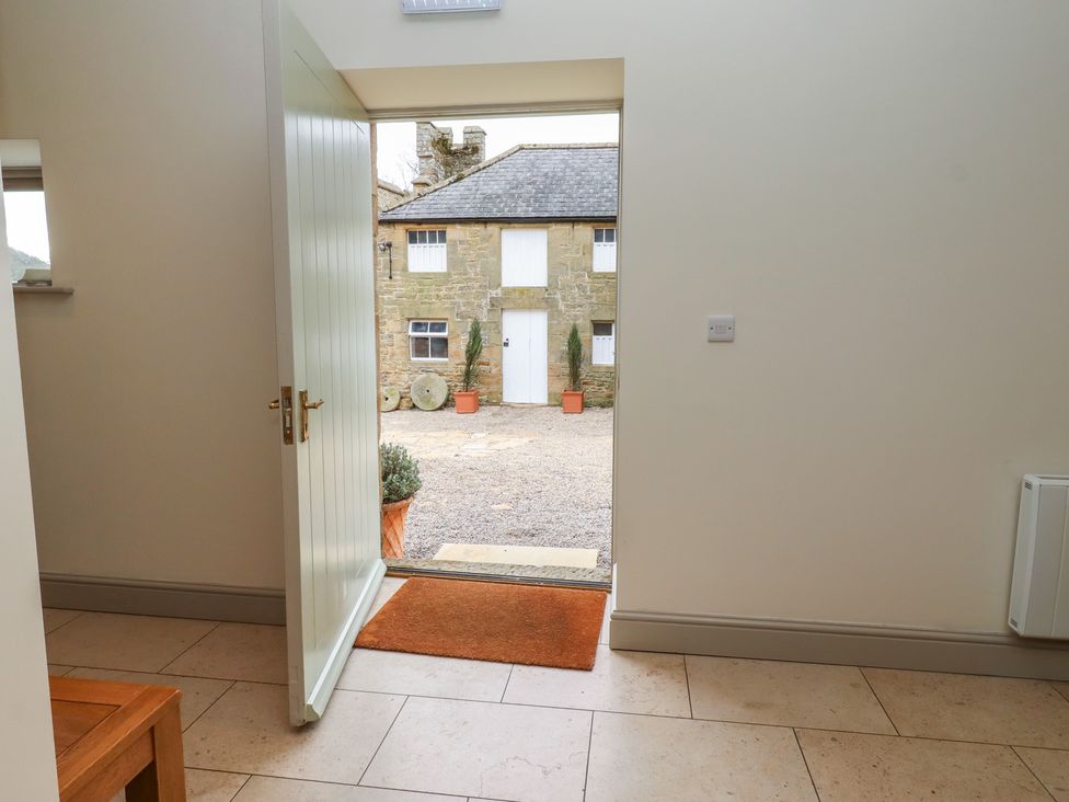 An entrance hall with a door leading to a courtyard at Cragg Lodge in West Woodburn