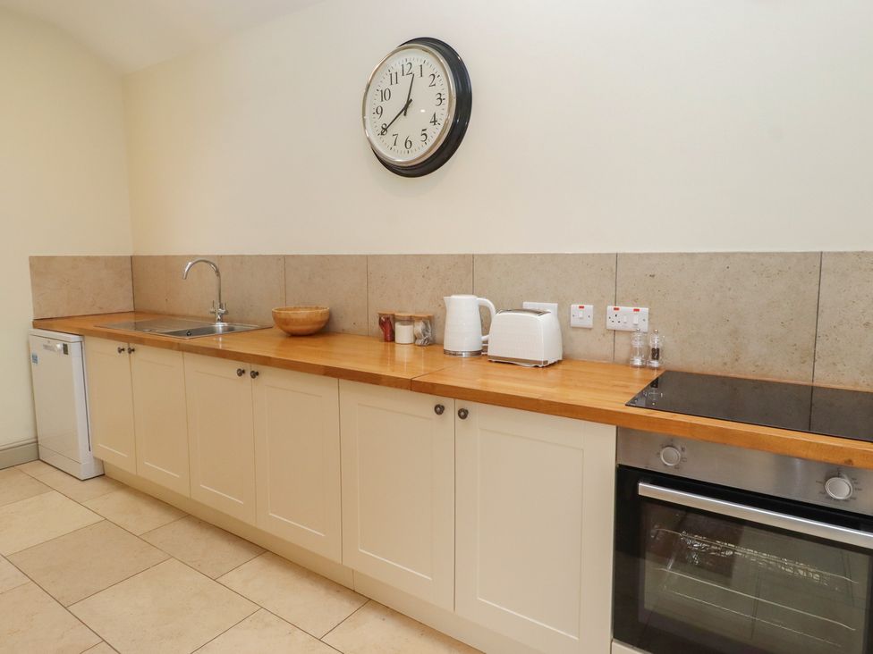 A kitchen with a sink, kettle, toaster, and oven at Cragg Lodge in West Woodburn