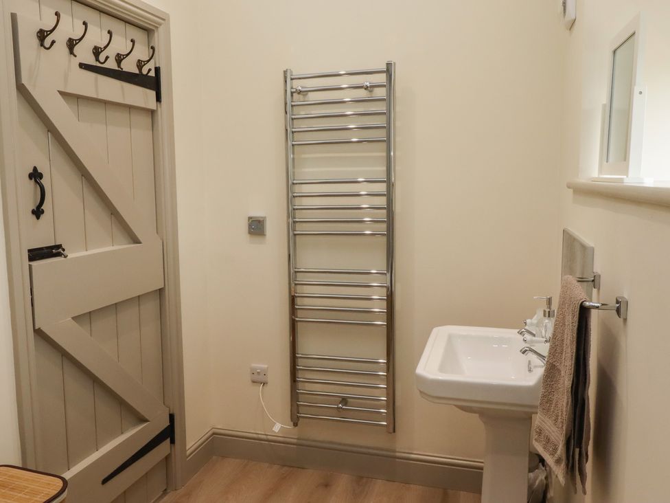 A bathroom with a sink and towel rail at Cragg Lodge in West Woodburn