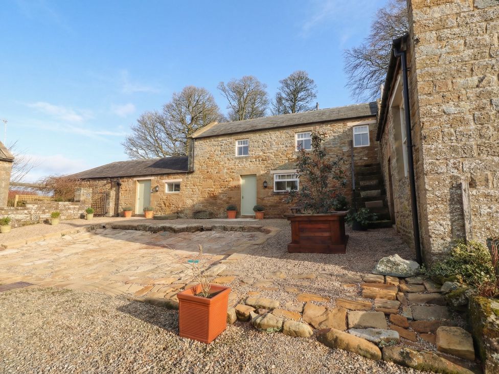 An outdoor area with buildings and trees at Cragg Lodge in West Woodburn