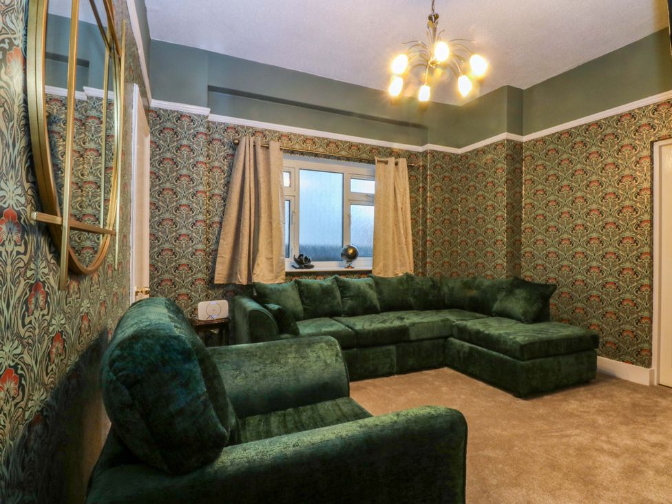 A living room with a sectional sofa and a window at Southbourne Manor in Llandudno
