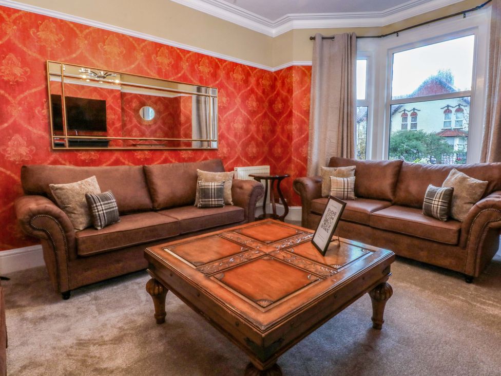 A living room with sofas and a table at Southbourne Manor in Llandudno