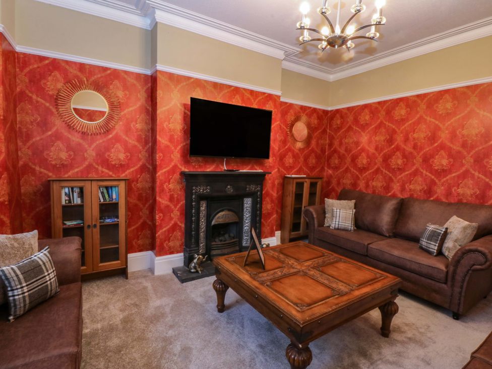A living room with a television and sofa at Southbourne Manor in Llandudno
