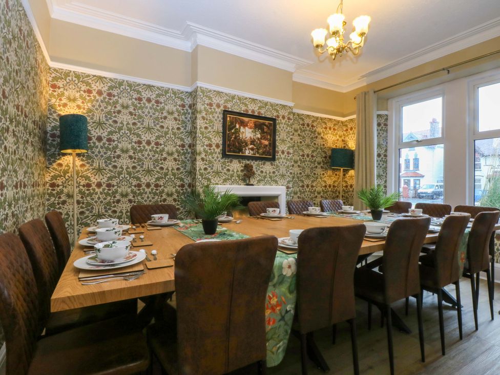 A dining room with a large table and chairs at Southbourne Manor in Llandudno