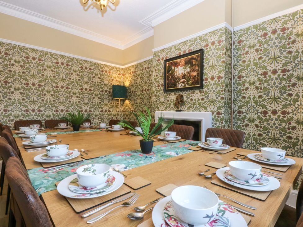 A dining room with a table set for dinner at Southbourne Manor in Llandudno