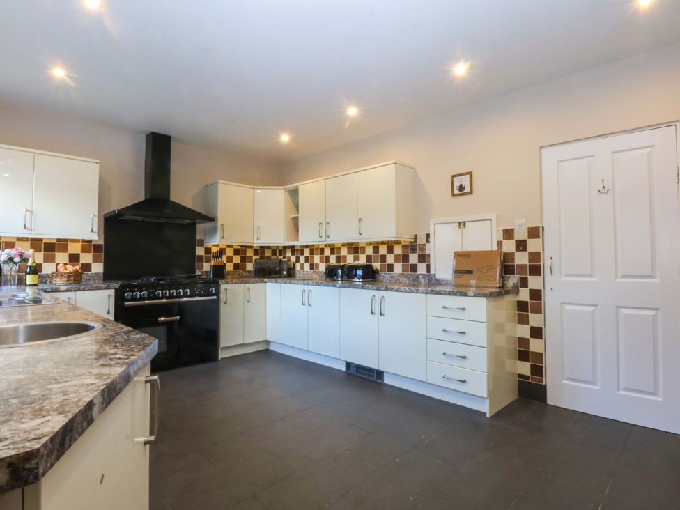 A kitchen with cabinets and a stove at Southbourne Manor in Llandudno