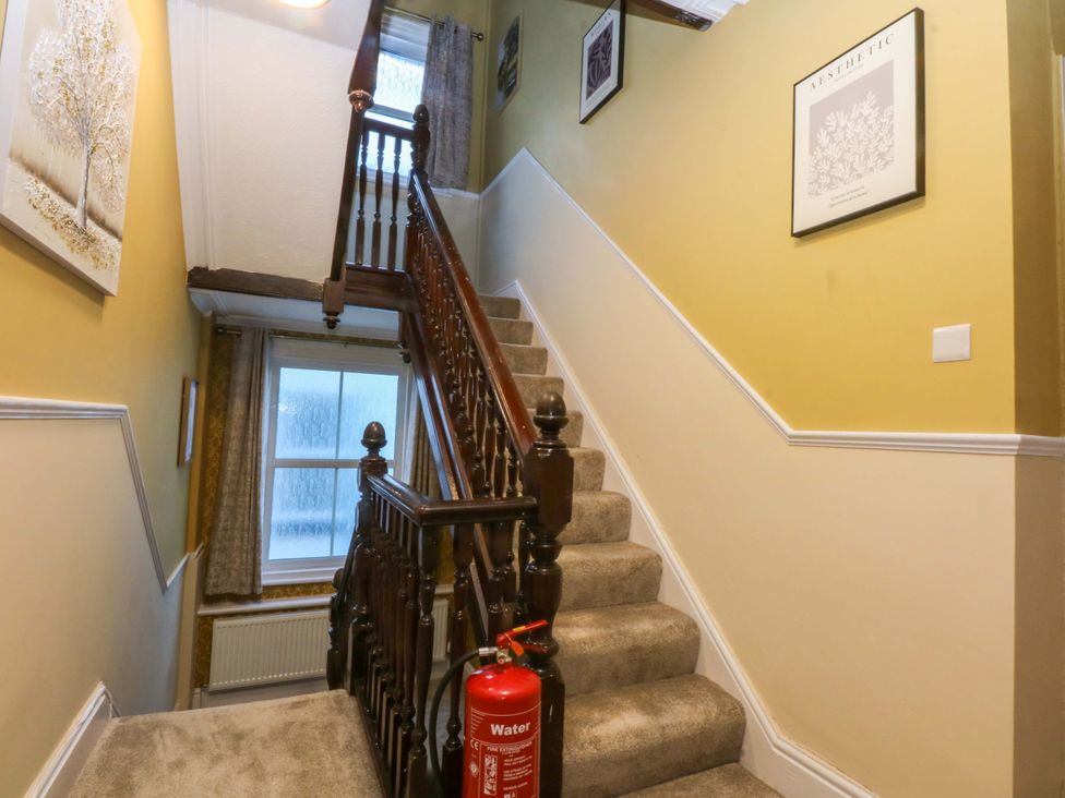A stairway with artwork and a fire extinguisher at Southbourne Manor in Llandudno