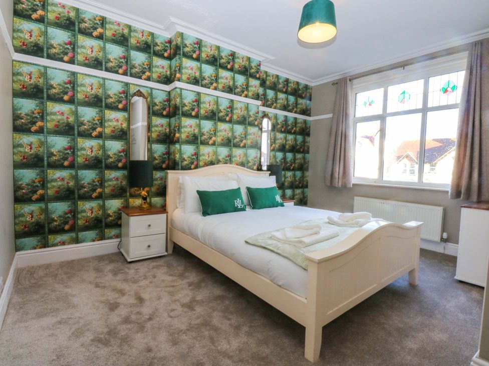 A bedroom featuring a bed, bedside table and a window at Southbourne Manor in Llandudno
